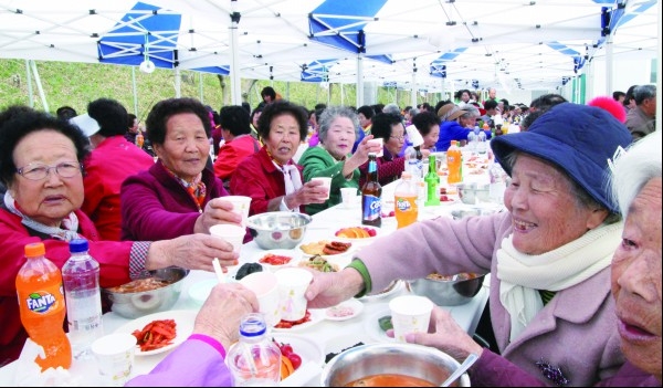 회남면 주민화합 한마당 축제에 참석한 어르신들이 준비된 점심식사를 맛있게 드시며 음료로 건배를 하고 있다.