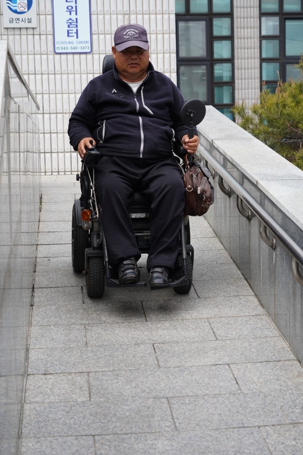 전동 휠체어를 이용하는 장애 2급인 이재길씨가 보은읍행정복지센터 경사로를 이용해 내려오고 있는 모습이다.