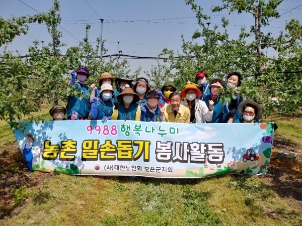 보은군 9988행복나누미 참여 강사들이 지난 5월 15일 삼승면 천남2리 과수 농가를 찾아 농촌일손돕기를 실시한 후 기념촬영을 했다.