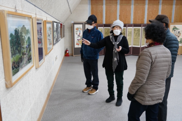 정기옥 회장이 대추골 먹그림 전시회에 참석한 관람객들에게 작품에 대한 설명을 하고 있다.